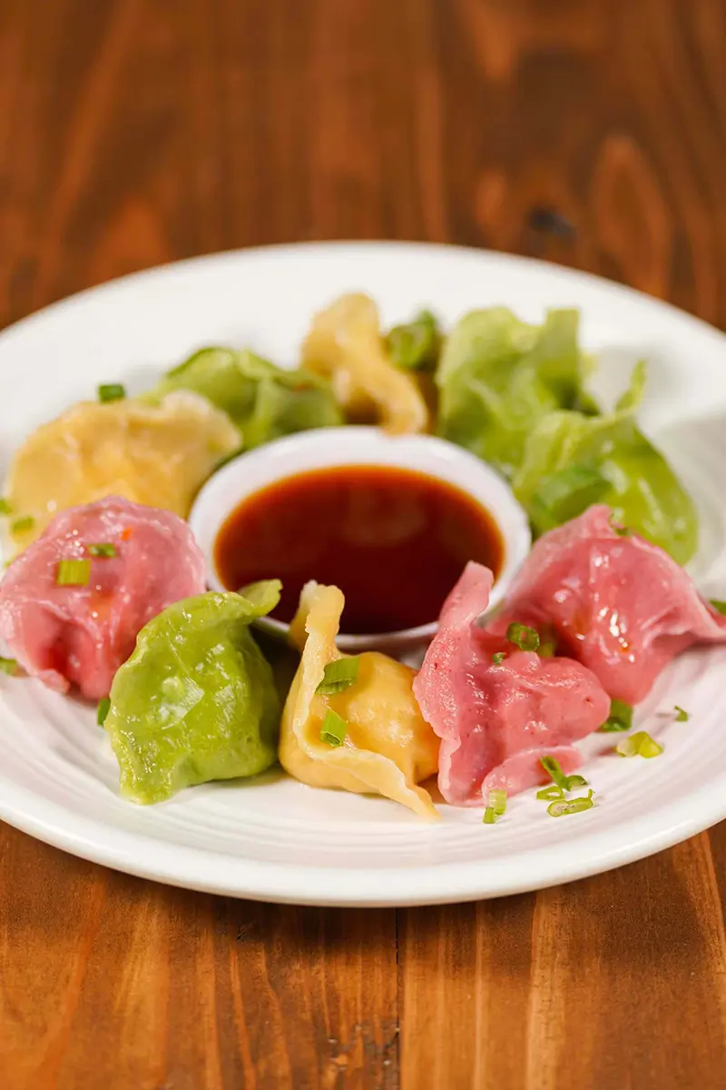Multi-colored dumplings with dipping sauce at One More Bite Dumpling House, a Chinese Restaurant in Chino